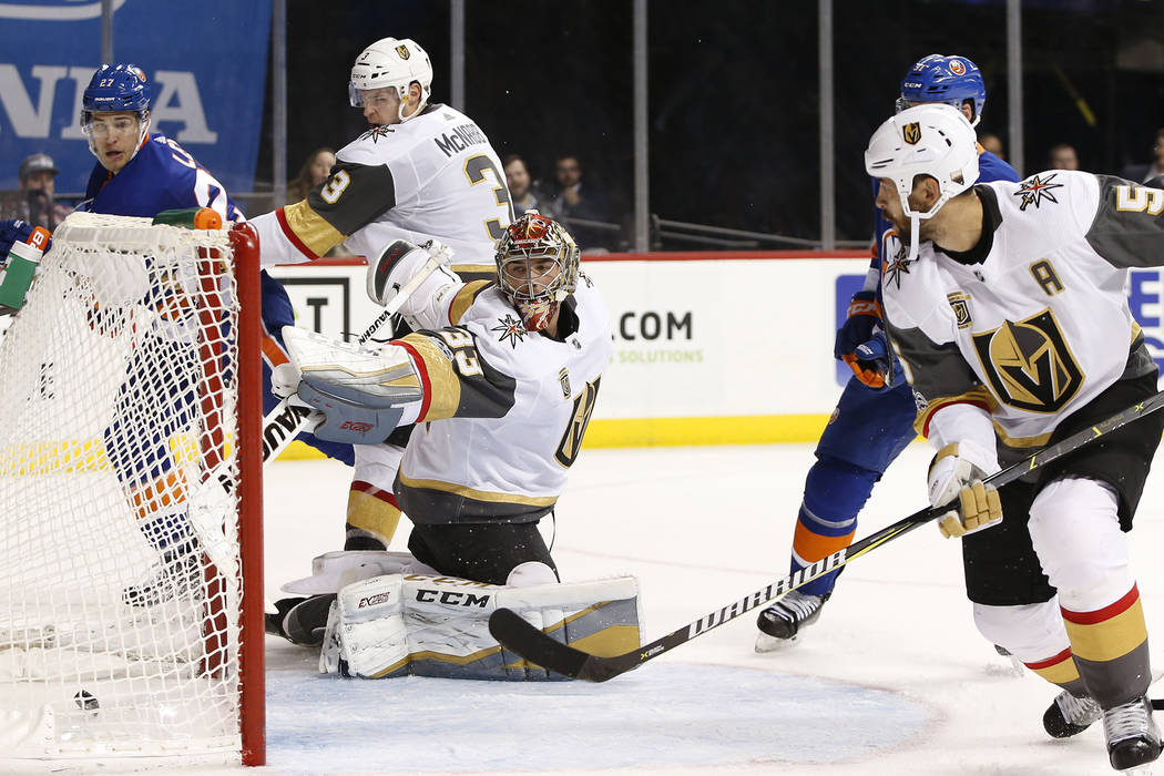 Vegas Golden Knights and Derek Engelland (5) watches as Vegas Knights goalie Maxime Lagace (33) watches Mathew Barzal's goal roll into the crease during the second period of an NHL hockey game aga ...