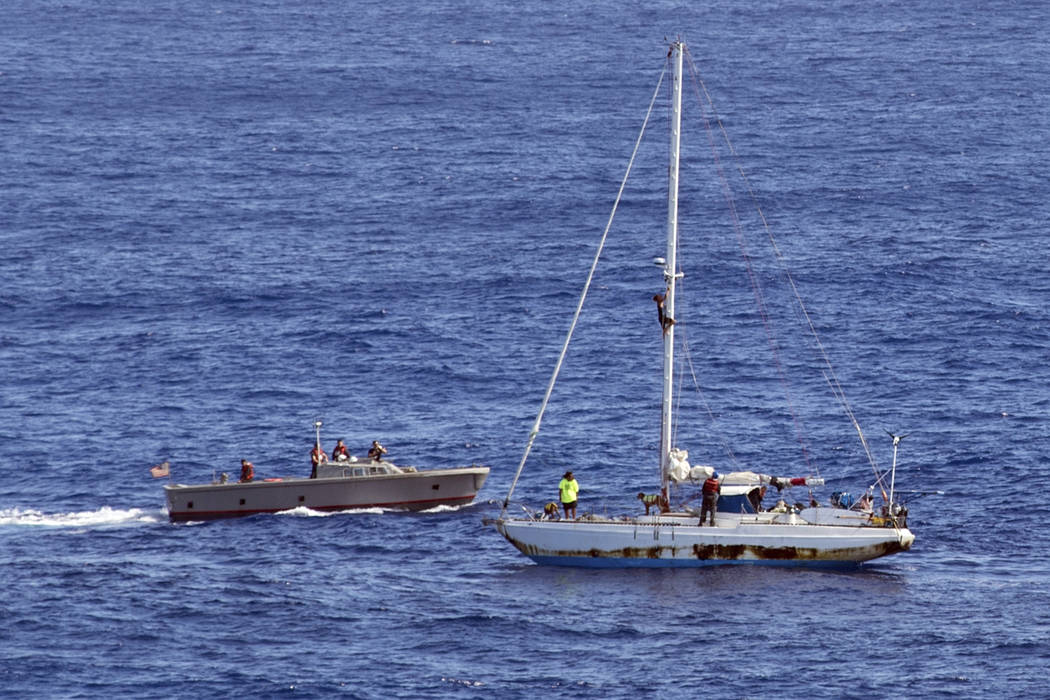 In this Wednesday, Oct. 25, 2017 photo, sailors from the USS Ashland approach a sailboat with two Honolulu women and their dogs aboard as they are rescued after being lost at sea for several month ...