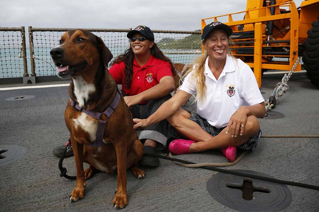 Jennifer Appel, right, and Tasha Fuiava sit with their dogs on the deck of the USS Ashland Monday, Oct. 30, 2017, at White Beach Naval Facility in Okinawa, Japan. The U.S. Navy ship arrived at t ...