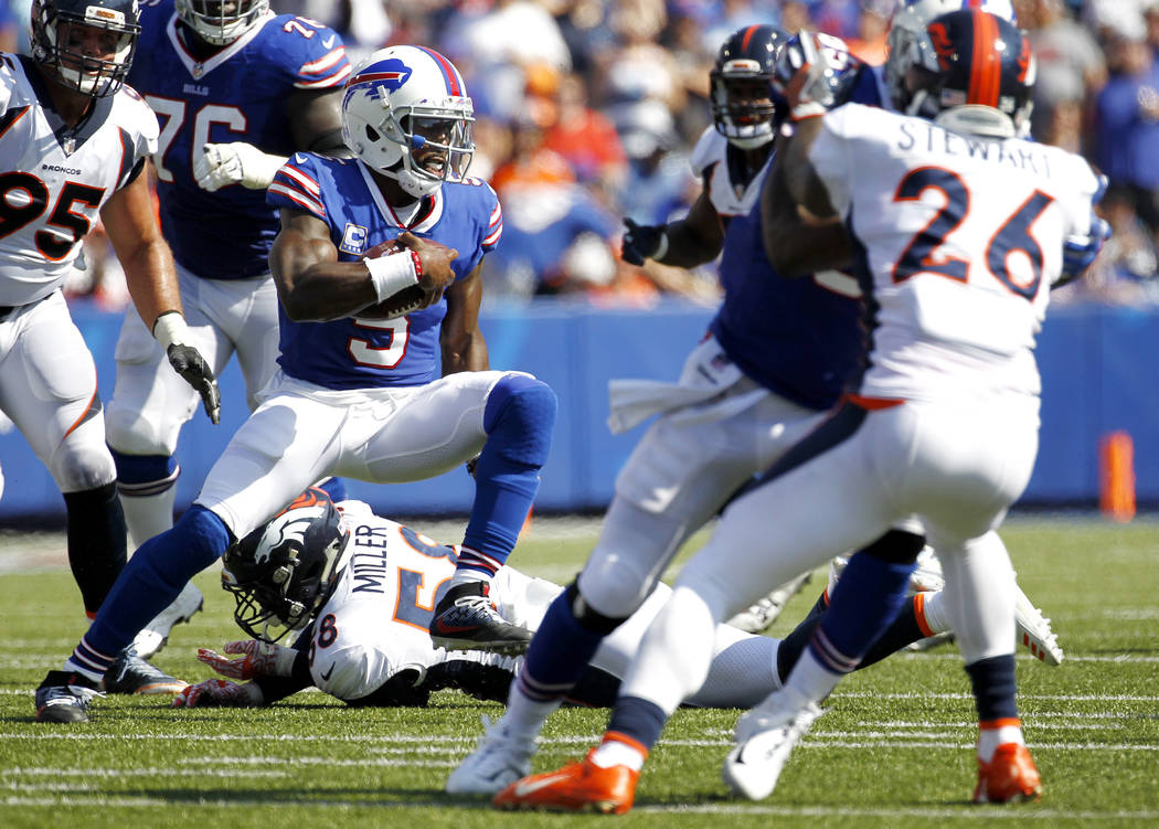 Buffalo Bills quarterback Tyrod Taylor (5) avoids a tackle by Denver Broncos outside linebacker Von Miller (58) during the first half of an NFL football game, Sunday, Sept. 24, 2017, in Orchard Pa ...