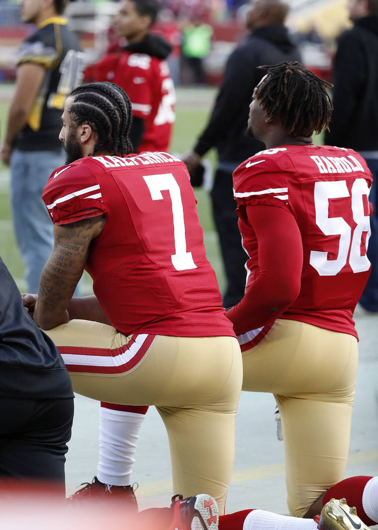 San Francisco 49ers quarterback Colin Kaepernick (7) and outside linebacker Eli Harold (58) kneel during the national anthem before an NFL football game against the Seattle Seahawks in Santa Clara ...