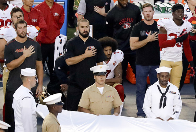 San Francisco 49ers quarterback Colin Kaepernick, middle, kneels during the national anthem before the team's NFL preseason football game against the San Diego Chargers, Thursday, Sept. 1, 2016, i ...