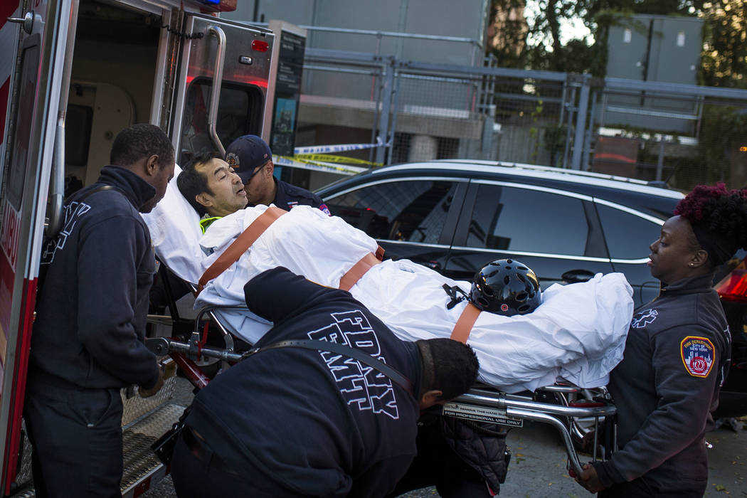 Emergency personnel carry a man into an ambulance after a motorist drove onto a busy bicycle path near the World Trade Center memorial and struck several people Tuesday, Oct. 31, 2017, in New York ...