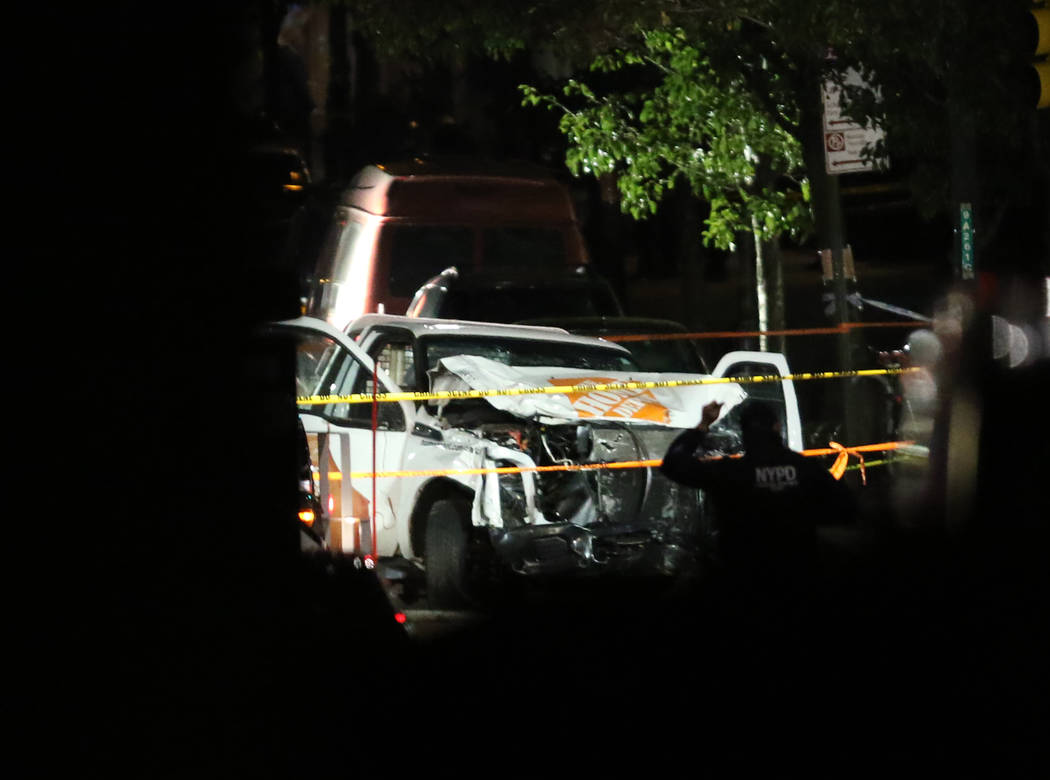 Authorities investigate near a rented Home Depot truck used to mow down pedestrians and cyclists along a busy bike path near the World Trade Center memorial on Tuesday, Oct. 31, 2017, killing at l ...