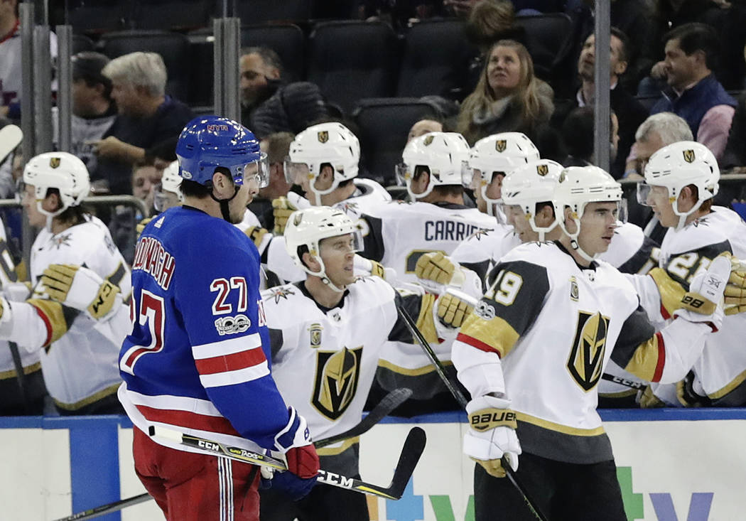 Vegas Golden Knights right wing Reilly Smith (19) celebrates with teammates after scoring a goal as New York Rangers' Ryan McDonagh (27) skates past them during the second period of an NHL hockey  ...