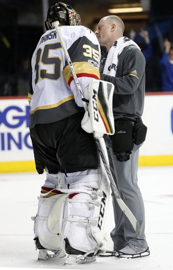 A trainer looks at Vegas Golden Knights goalie Oscar Dansk (35) of Sweden who left the game with an apparent injury during the second period of an NHL hockey game in New York, Monday, Oct. 30, 201 ...