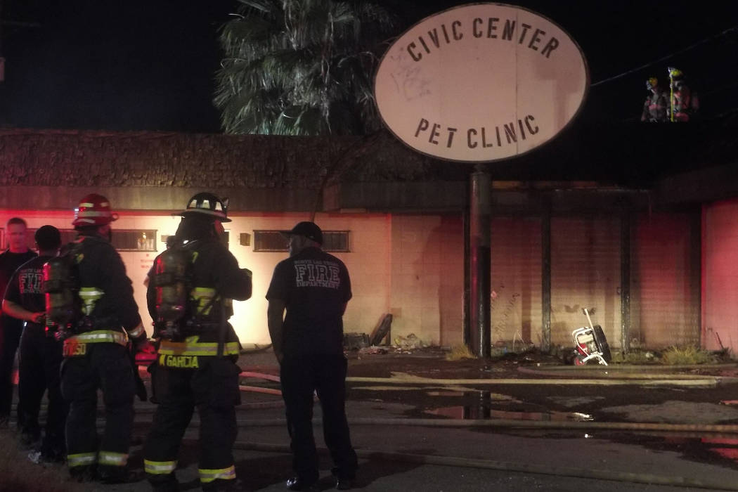 Firefighters from Las Vegas and North Las Vegas fire departments check for hot spots after a fire at an abandoned animal clinic. (Max Michor/Las Vegas Review-Journal)