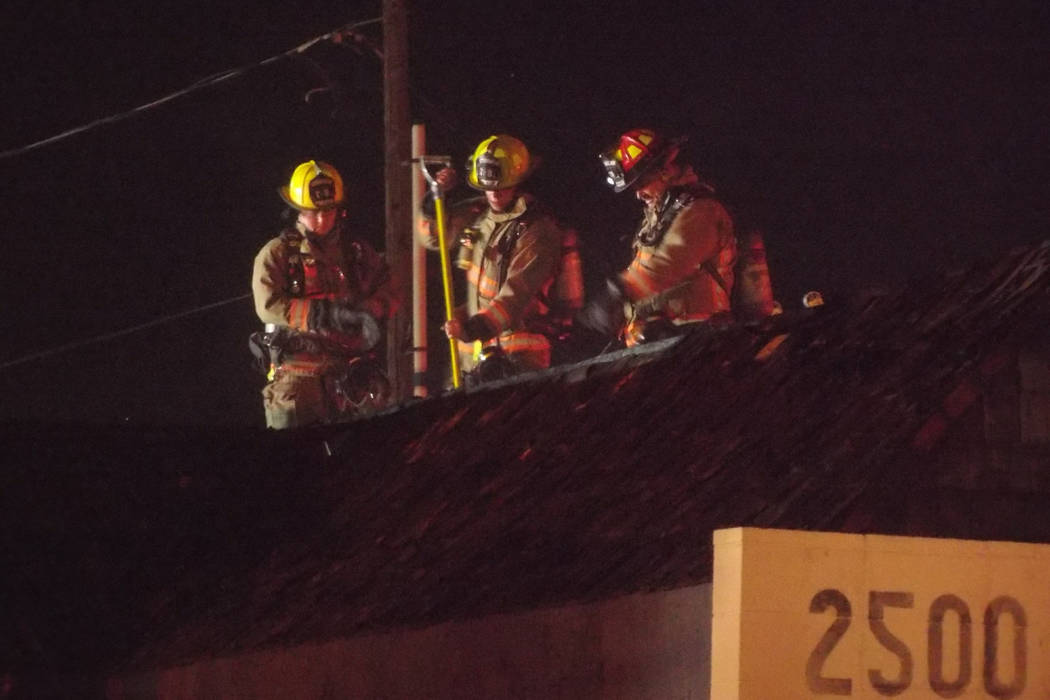 Firefighters from Las Vegas and North Las Vegas fire departments check for hot spots after a fire at an abandoned animal clinic. (Max Michor/Las Vegas Review-Journal)