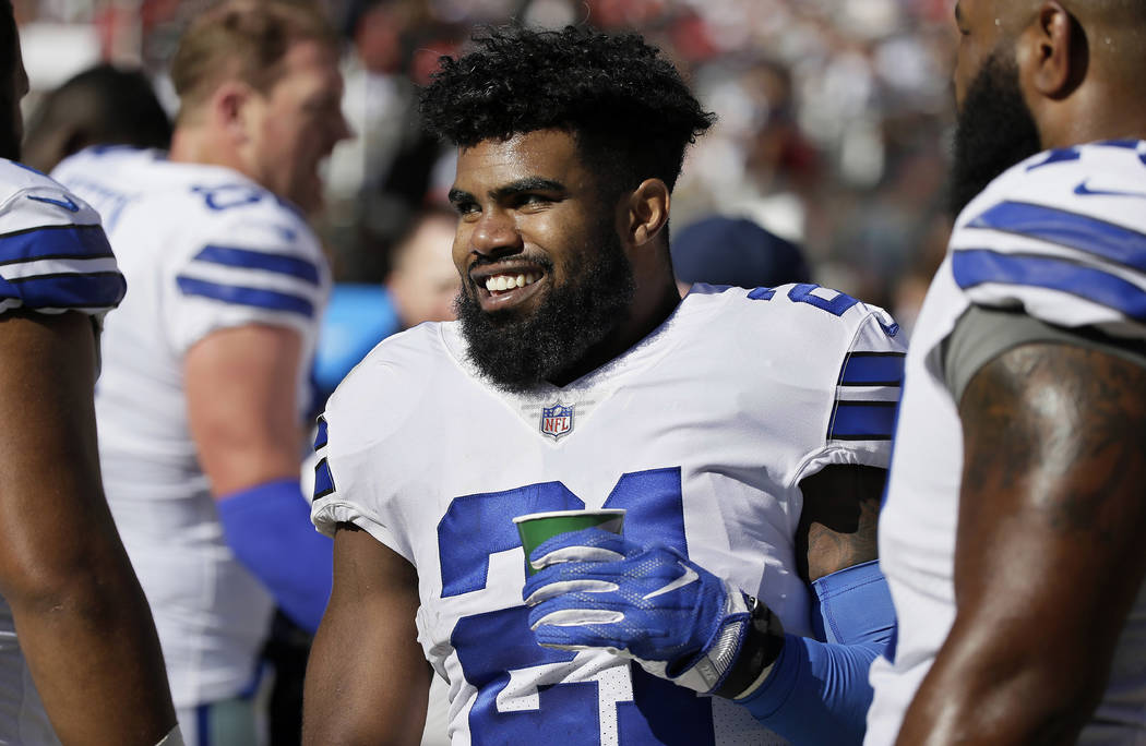 Dallas Cowboys running back Ezekiel Elliott smiles on the sideline after scoring a touchdown during the second half of an NFL football game against the San Francisco 49ers in Santa Clara, Calif., ...