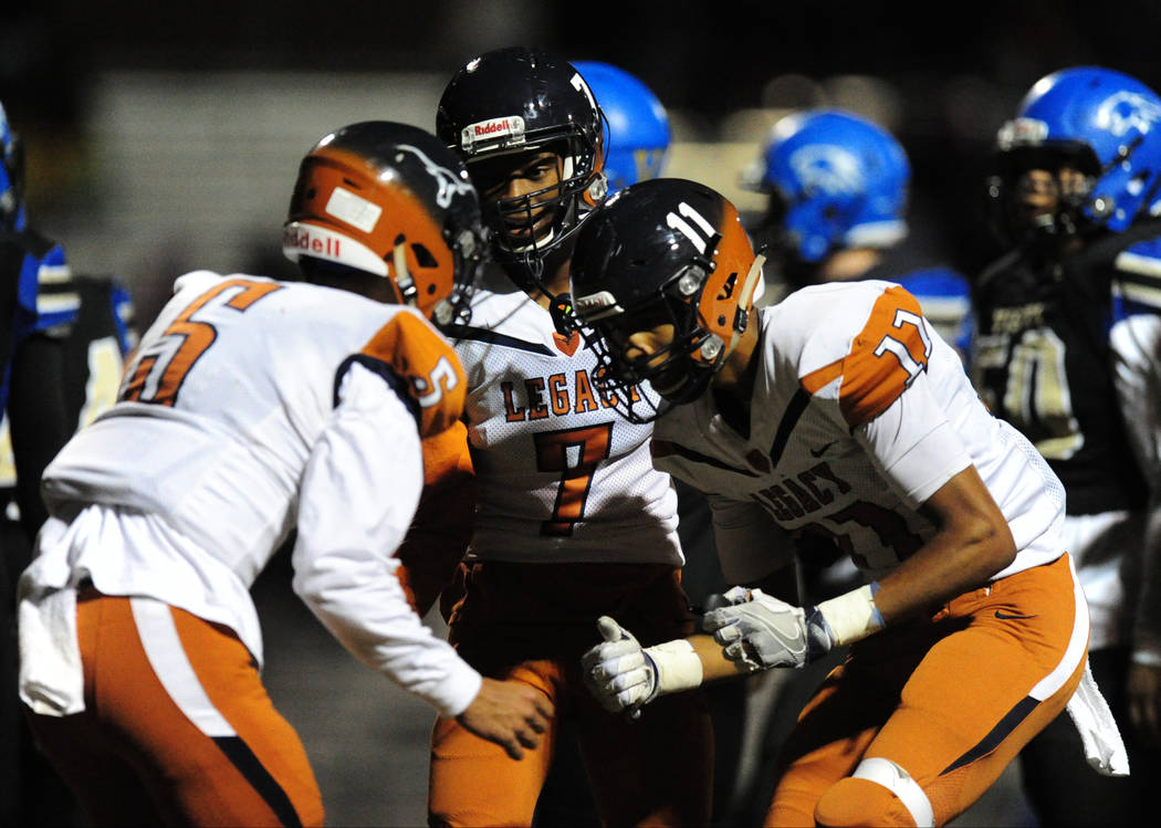 Legacy player Anthony Myles (7), quarterback Roberto Valenzuela (5) and Davick Clark (11) celebrate a touchdown against Sierra Vista in the second half of their prep football game at Sierra Vista ...