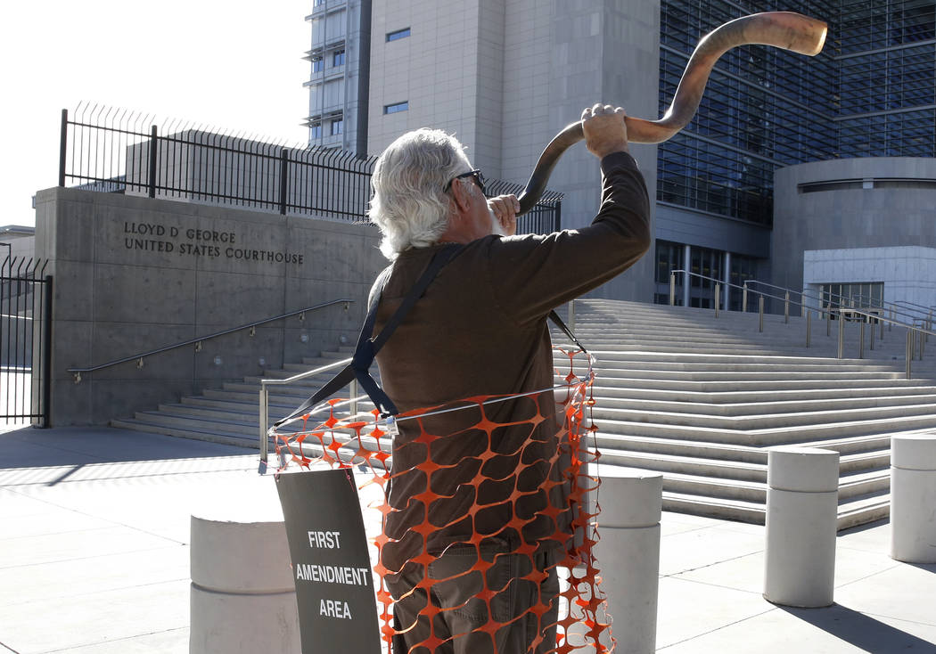 Brand Thornton blows a horn outside the Lloyd George U.S. Courthouse on Tuesday, Nov. 7, 2017 in support of Cliven Bundy's two sons and an independent militia man, who are on trial over the Bunker ...