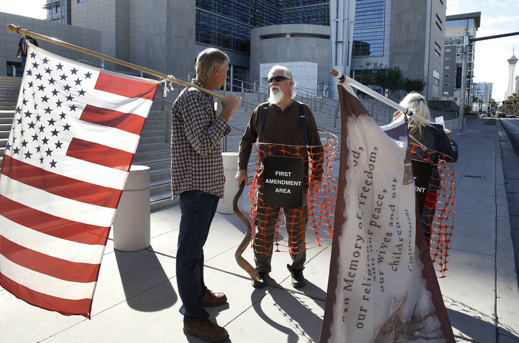 Jeff Banta, left, Brand Thornton, and Shawna Cox, right, protest outside the Lloyd George U.S. Courthouse on Tuesday, Nov. 7, 2017 in support of Cliven Bundy's two sons and an independent militia  ...
