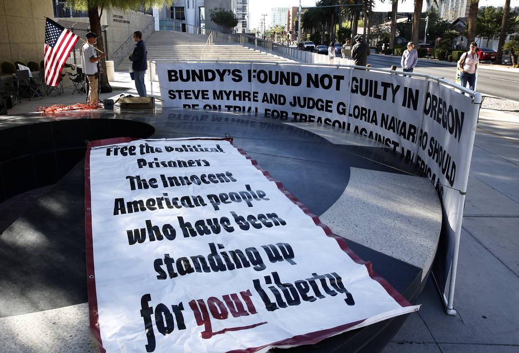 Bryce Poulsen, left, protests outside the Lloyd George U.S. Courthouse on Tuesday, Nov. 7, 2017 in support of Cliven Bundy's two sons and an independent militia man, who are on trial over the Bunk ...