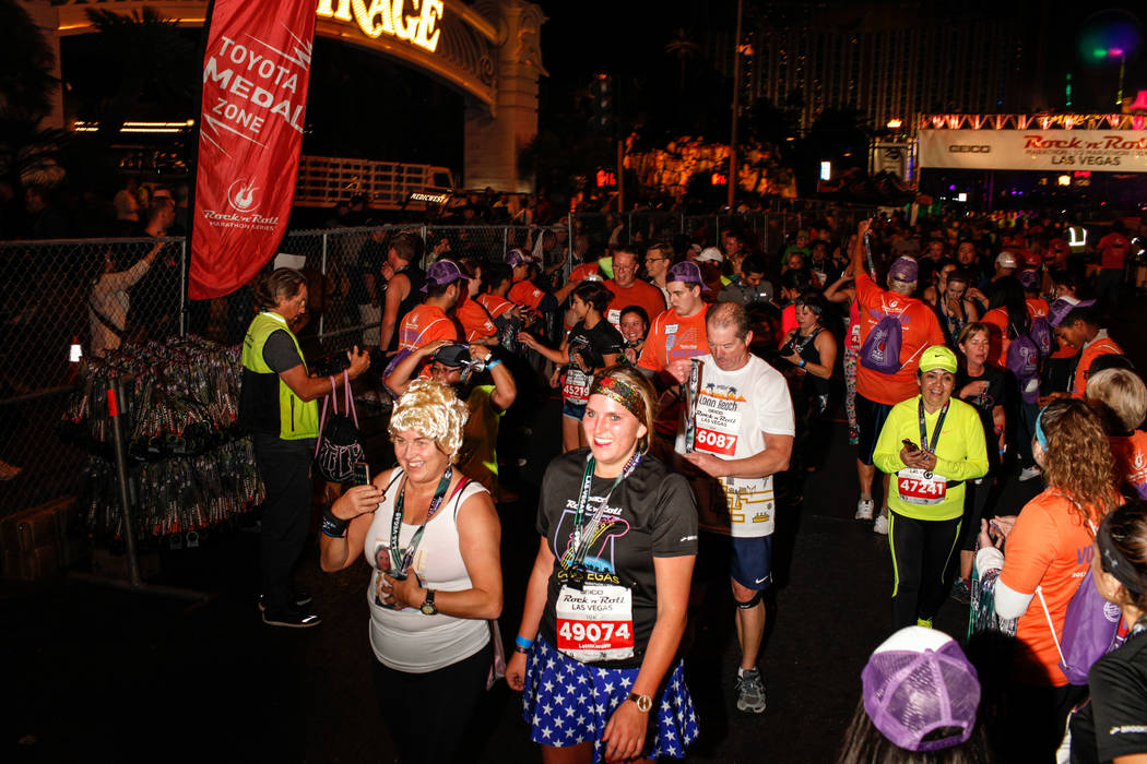 Angela Newman, left, and her daughter Siona Neumann, right, both of Germany, cross the finish line at the 10K run of the Rock 'n' Roll Las Vegas Marathon along the Strip near The Mirage in Las Veg ...