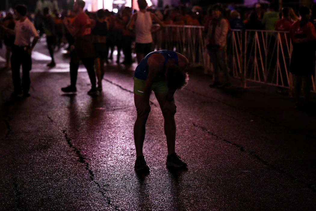 Mark Burgess of Buckhurst Hill catches his breath after crossing the finish line at the half marathon run of the Rock 'n' Roll Las Vegas Marathon along the Strip near The Mirage in Las Vegas, Sund ...
