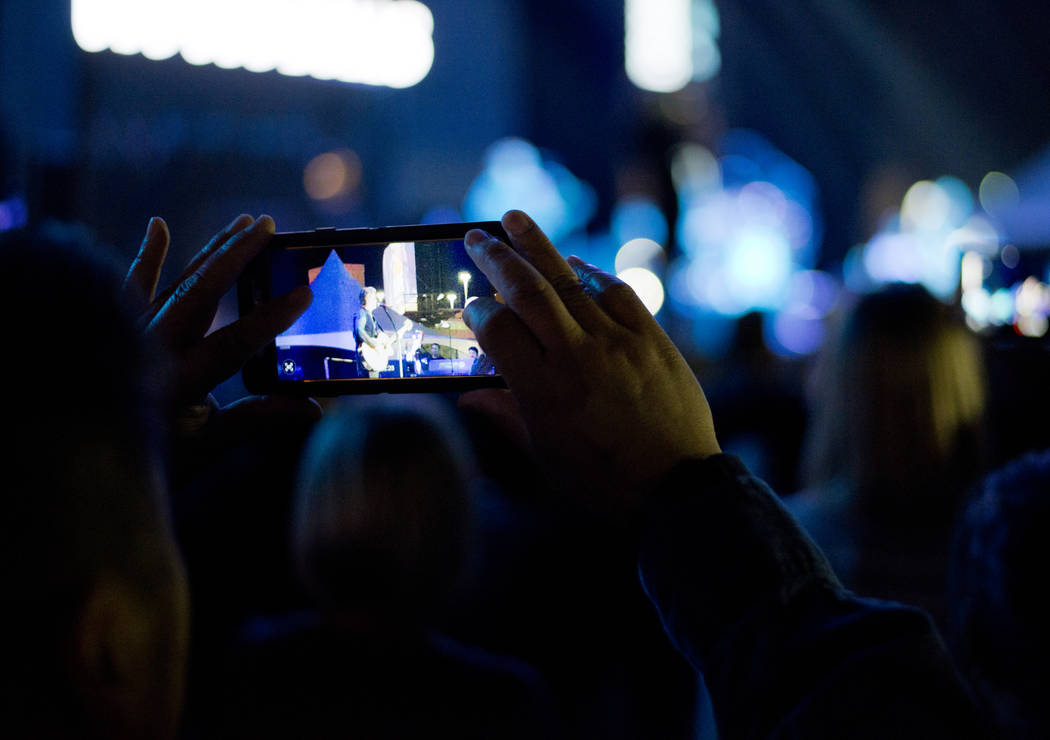 A man takes a photo as the Goo Goo Dolls perform after the 5K portion of the Rock ԮՠRoll Las Vegas Marathon at the Las Vegas Festival Grounds on The Strip on Saturday, Nov. 11, 2017. D ...