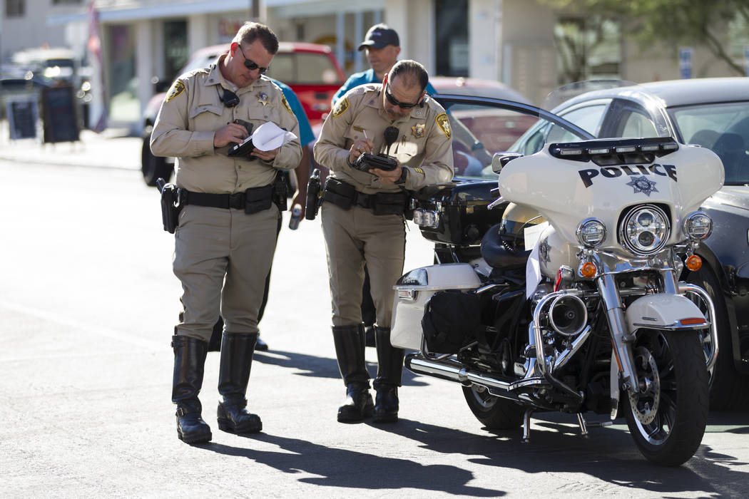 Las Vegas police officers at the scene of an accident between a truck and a driverless electric shuttle near Fremont Street and S. 6th Street in Las Vegas during the launch day of the autonomous v ...