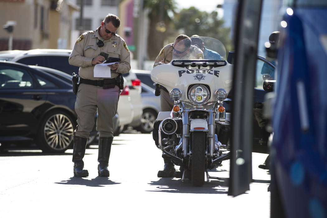 Las Vegas police officers at the scene of an accident between a truck and a driverless electric shuttle near Fremont Street and S. 6th Street in Las Vegas during the launch day of the autonomous v ...