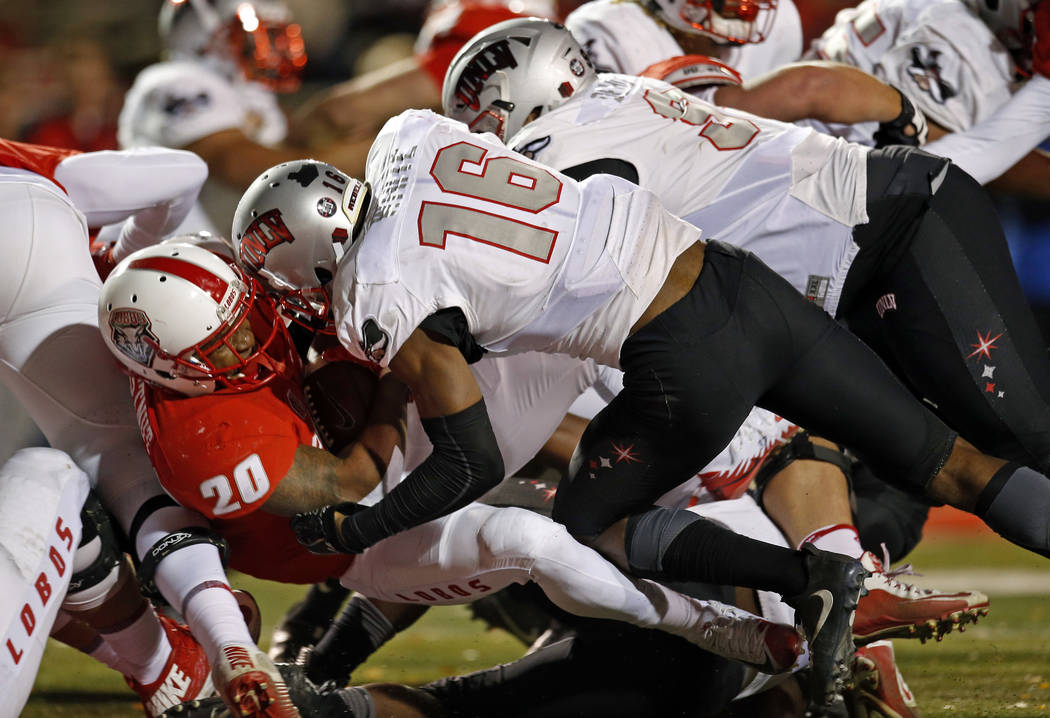 New Mexico running back Daryl Chestnut (20) scores a touchdown against the defense of UNLV linebacker Javin White (16) and defensive lineman Nick Dehdashtian (98) during the first half of an NCAA  ...