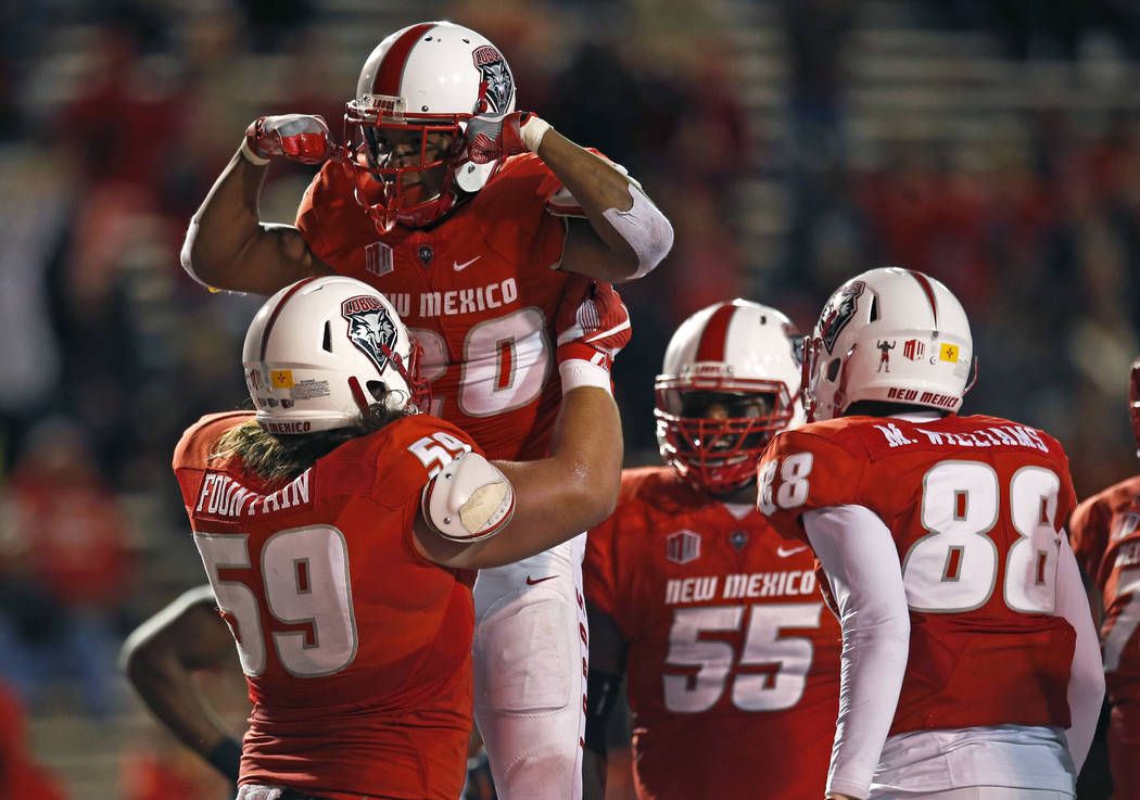 New Mexico running back Daryl Chestnut (20) celebrates with teammate Blaise Fountain (59) after scoring a touchdown against UNLV during the first half of an NCAA college football game in Albuquerq ...