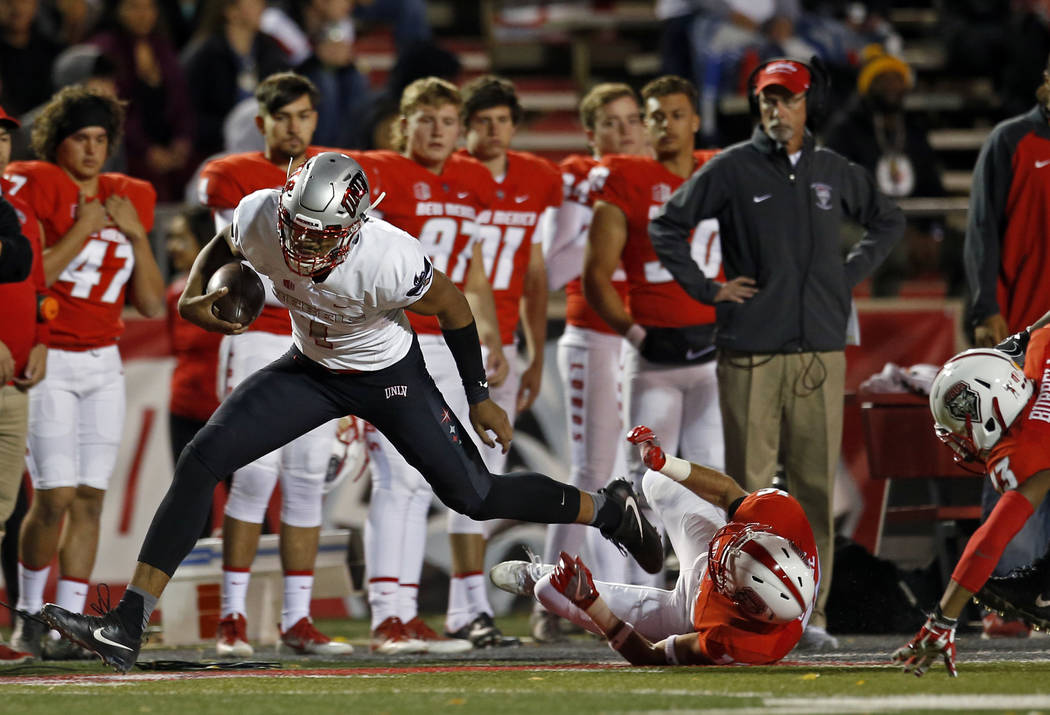 UNLV quarterback Armani Rogers, left, avoids the tackle of New Mexico safety Jacob Girgle (16) during the first half of an NCAA college football game in Albuquerque, N.M., Friday, Nov. 17, 2017. ( ...