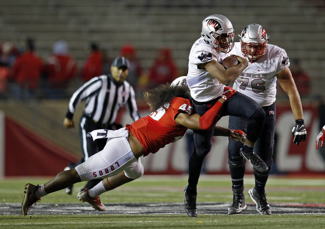 UNLV quarterback Armani Rogers is stopped by New Mexico linebacker Evahelotu Tohi (45) during the first half of an NCAA college football game in Albuquerque, N.M., Friday, Nov. 17, 2017. (AP Photo ...