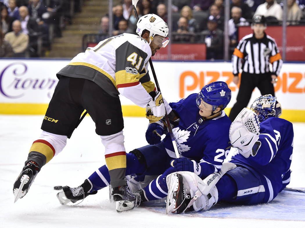 Vegas Golden Knights left wing Pierre-Edouard Bellemare (41) checks Toronto Maple Leafs center William Nylander (29) into goalie Frederik Andersen (31) during the first period of an NHL hockey gam ...