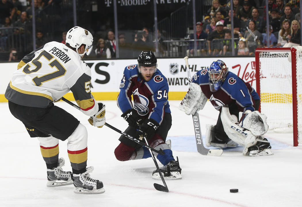 Golden Knights' David Perron (57) attempts to get the puck past Colorado Avalanche's Anton Lindholm (54) as Colorado Avalanche goalie Semyon Varlamov (1) defends during an NHL hockey game at T-Mob ...