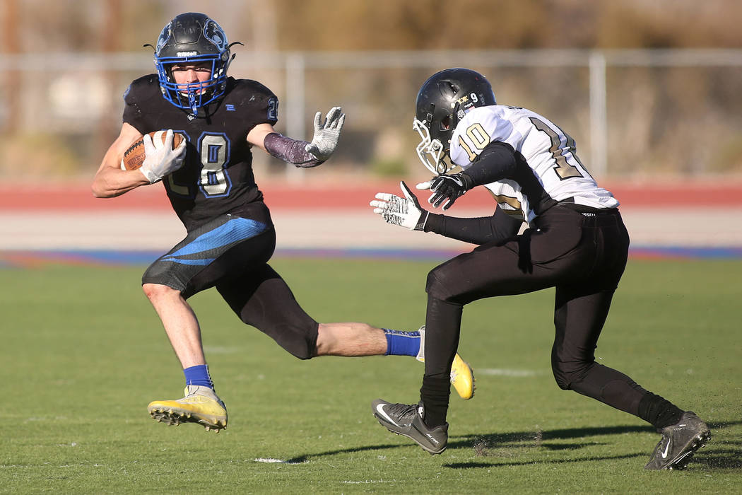 Pahranagat Valley player Hunter Hollingshead (28) tries to avoid Corvell Fisher (10) during the class A state championship game against at Indian Springs High School in Indian Springs, Saturday, N ...