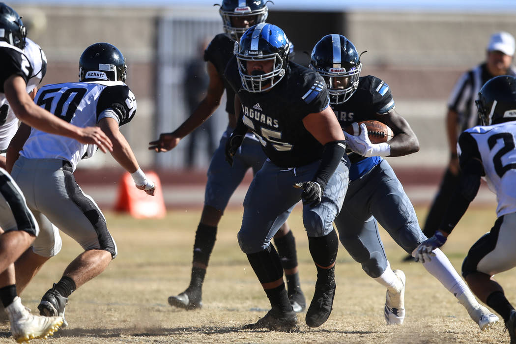 Desert Pines's Jyden King (12), right, runs the ball against Spring Creek during the first quarter of the Class 3A State football game at Desert Pines High School in Las Vegas, Saturday, Nov. 18,  ...