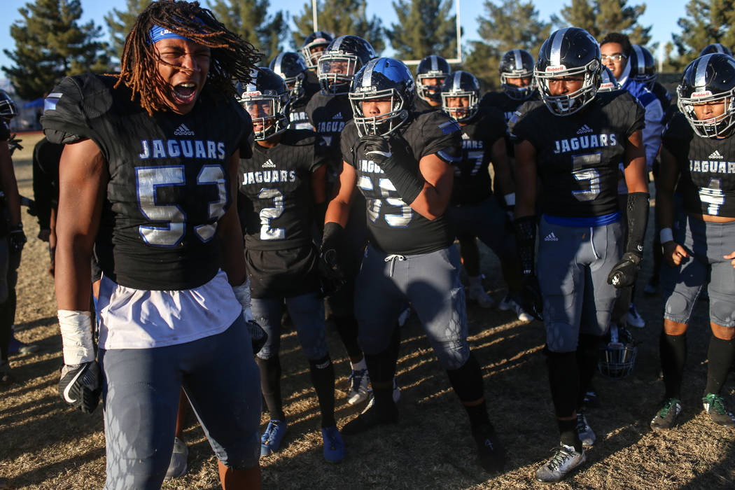 Desert Pines' Lorenzo Sheldon Brown (53), left, celebrates with teammates after defeating Spring Creek 50-28 in the end of the Class 3A State football game at Desert Pines High School in Las Vegas ...