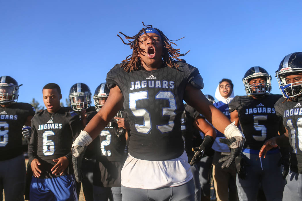 Desert Pines' Lorenzo Sheldon Brown (53), center, celebrates with teammates after defeating Spring Creek 50-28 in the end of the Class 3A State football game at Desert Pines High School in Las Veg ...