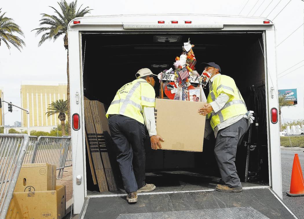 Clark County employees load crosses and items onto a truck at the Route 91 Harvest memorial at the Welcome to Fabulous Las Vegas sign Sunday, Nov. 12, 2017. Fifty eight crosses and items that were ...