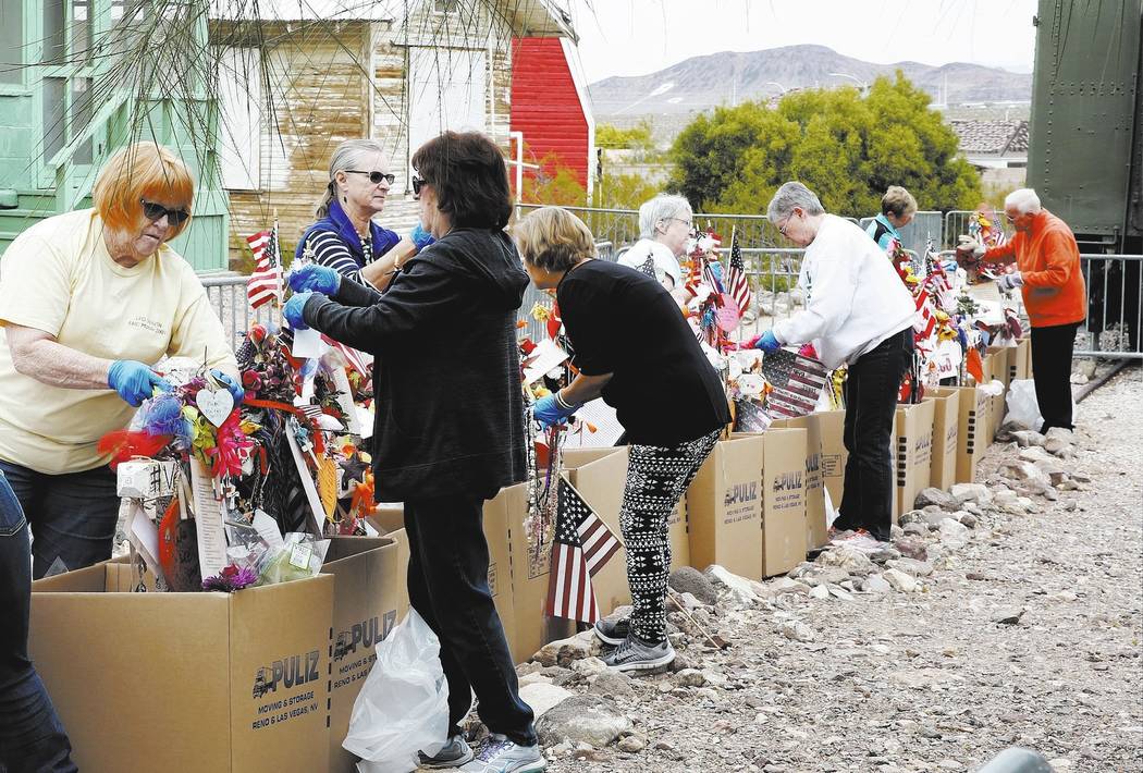 Volunteers, including Andrea Frazier, left, and Geraldine Ortiz, right, remove fragile artifacts from the crosses at the clark County Museum in Henderson Sunday, Nov. 12, 2017. Fifty eight crosses ...