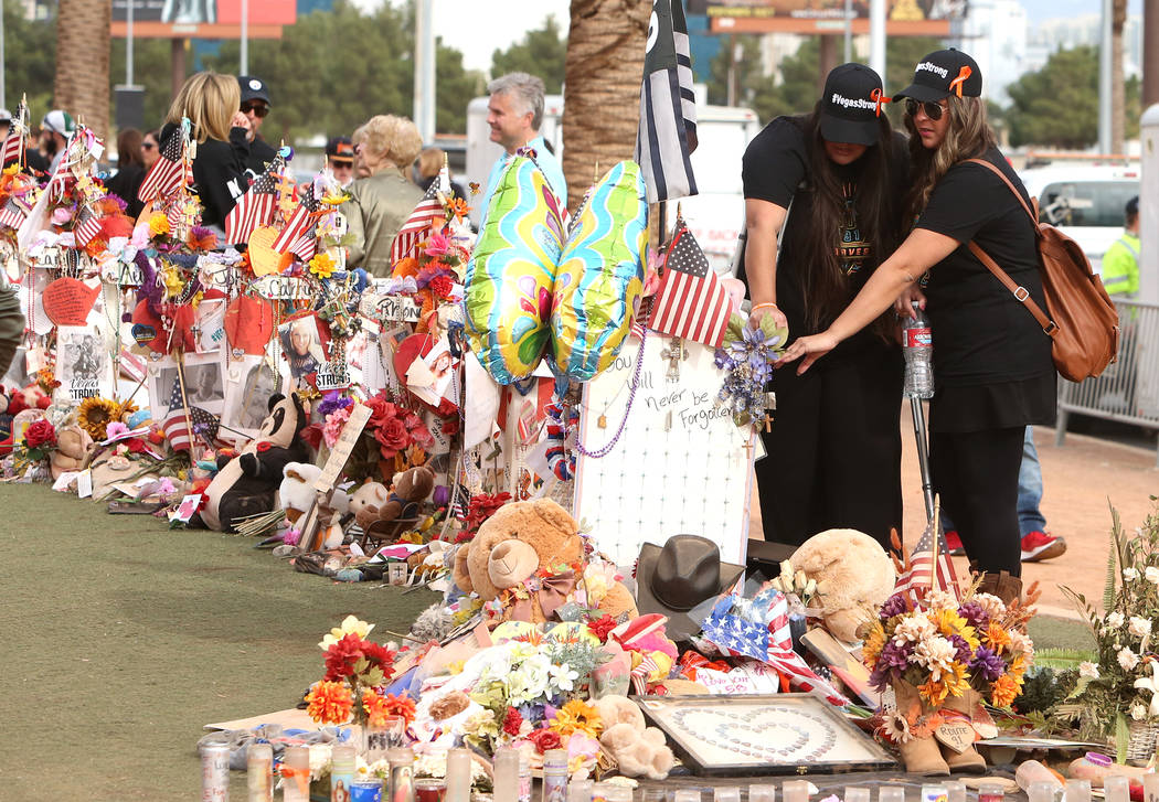 Las Vegas shooting survivors, including Lulu Farina, right, visit the Route 91 Harvest memorial at the Welcome to Fabulous Las Vegas sign Sunday, Nov. 12, 2017, in Las Vegas. Fifty eight crosses a ...