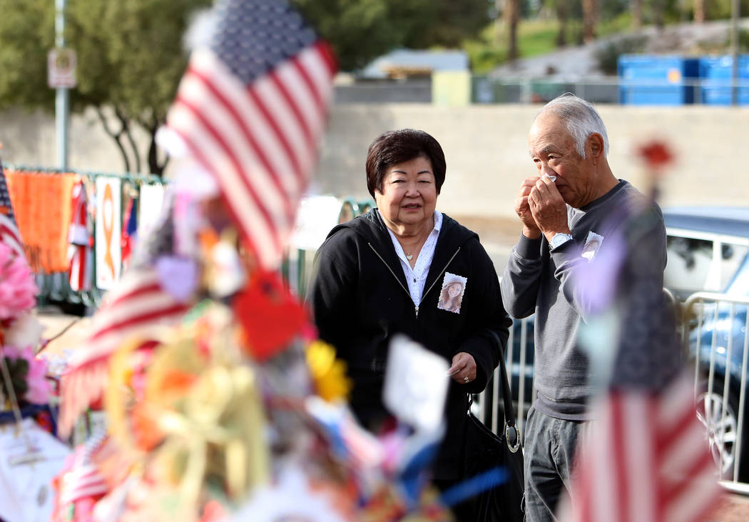 Haven Kimura, right, visits the cross of his daughter Nicole with his sister Violet at the Route 91 Harvest memorial at the Welcome to Fabulous Las Vegas sign Sunday, Nov. 12, 2017, in Las Vegas. ...