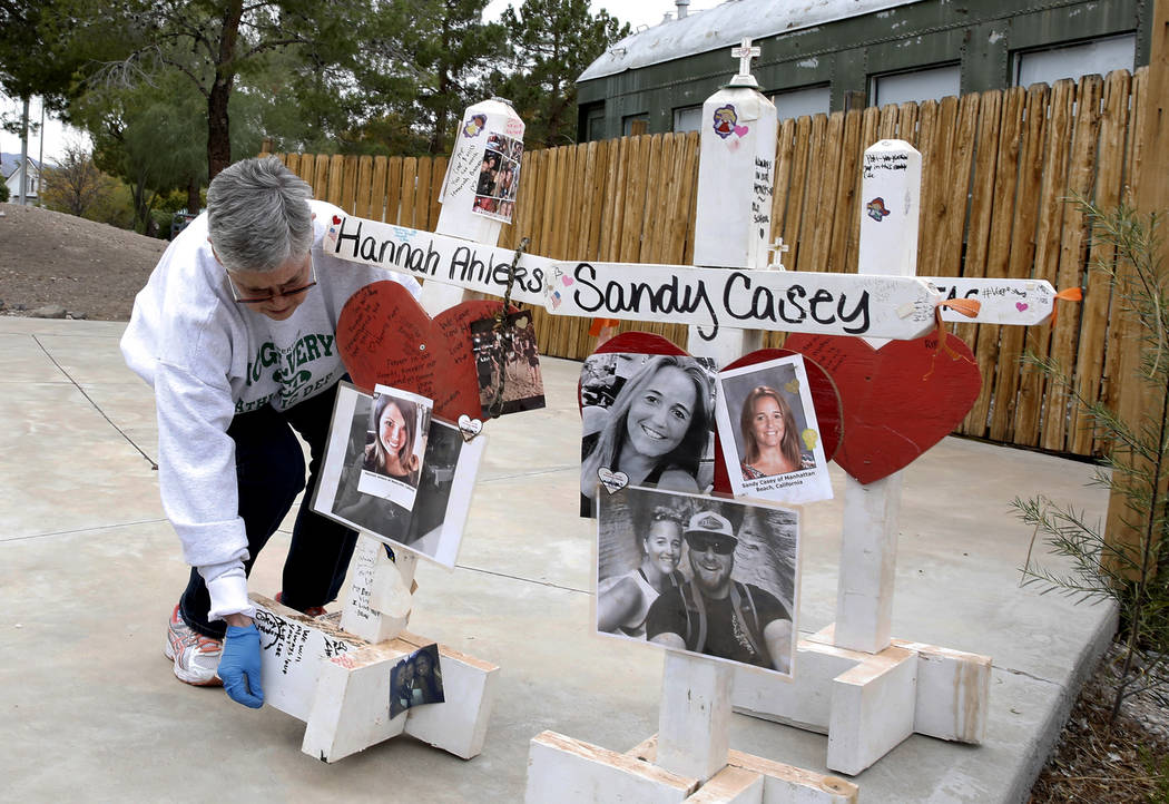 Jeanne Brady displays crosses on the amphitheater stage at the clark County Museum in Henderson Sunday, Nov. 12, 2017. Fifty eight crosses and items that were erected in honor of the Oct. 1 shooti ...