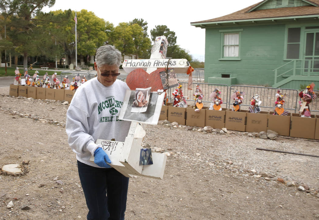 Jeanne Brady, a volunteer, carries a cross after removing fragile artifacts from the crosses at the clark County Museum in Henderson Sunday, Nov. 12, 2017. Fifty eight crosses and items that were ...