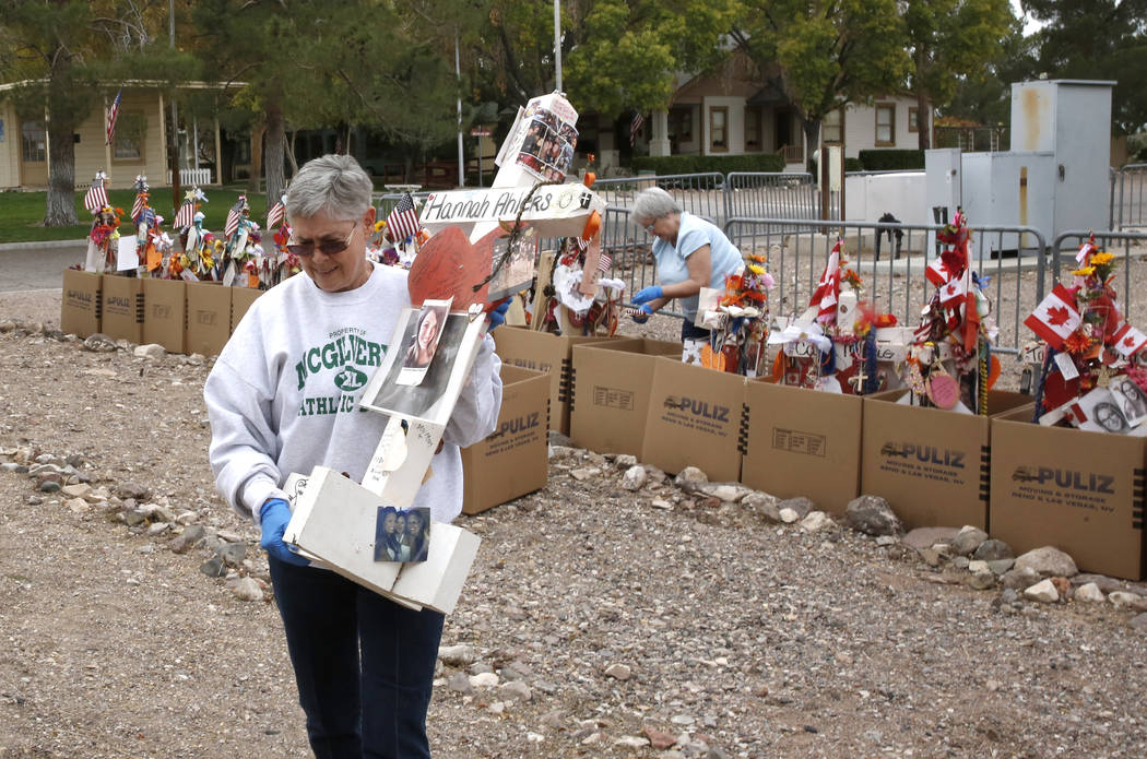 Jeanne Brady, a volunteer, carries a cross after removing fragile artifacts from the crosses at the clark County Museum in Henderson Sunday, Nov. 12, 2017. Fifty eight crosses and items that were  ...