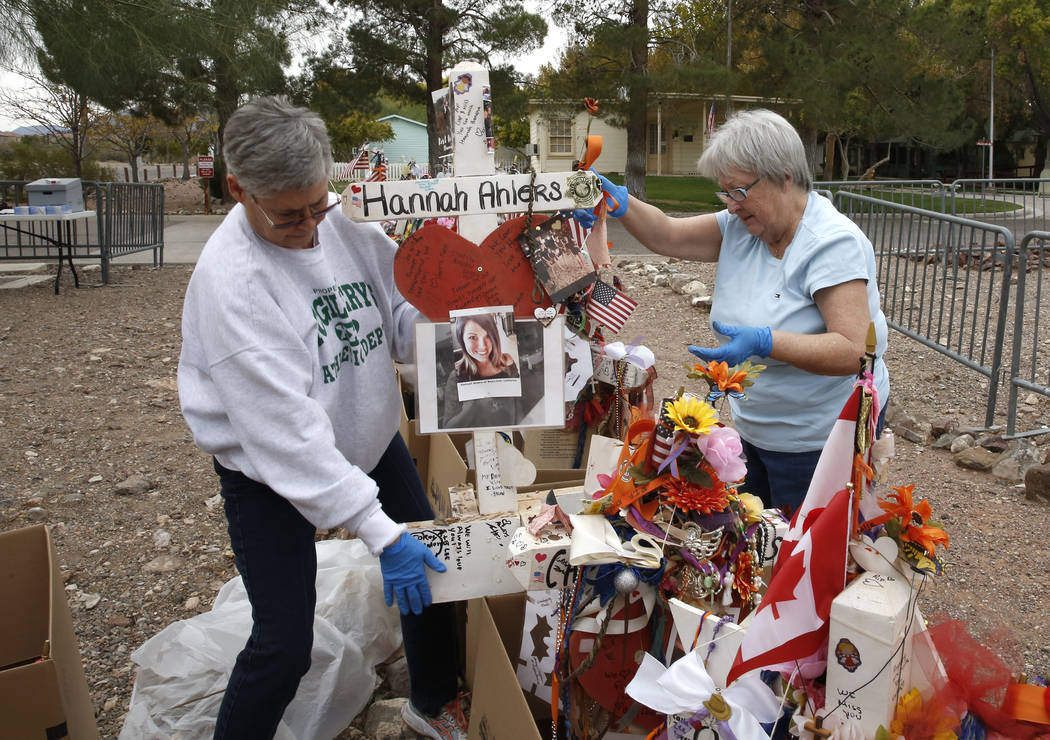 Jeanne Brady, left, and Janet Bremer, volunteers, remove fragile artifacts from the crosses at the clark County Museum in Henderson Sunday, Nov. 12, 2017. Fifty eight crosses and items that were e ...