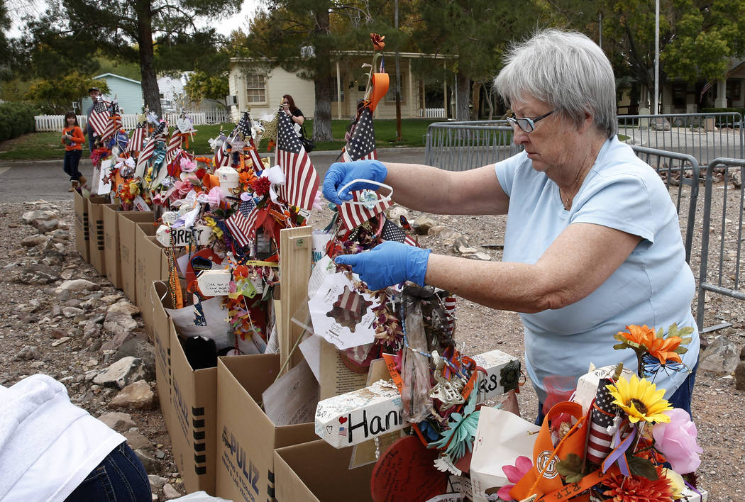 Janet Bremer, a volunteer, removes fragile artifacts from the crosses at the clark County Museum in Henderson Sunday, Nov. 12, 2017. Fifty eight crosses and items that were erected in honor of the ...