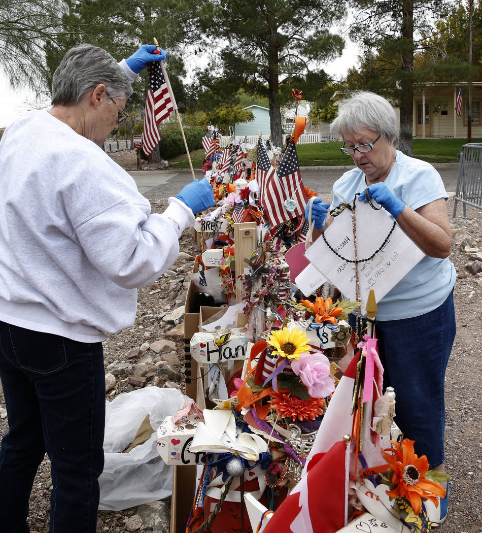 Jeanne Brady, left, and Janet Bremer, volunteers, remove fragile artifacts from the crosses at the clark County Museum in Henderson Sunday, Nov. 12, 2017. Fifty eight crosses and items that were e ...