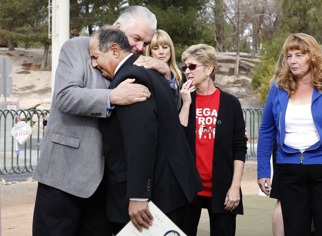 Clark County Commissioner Steve Sisolak, left, hugs Greg Zanis after declaring Sunday “Greg Zanis Day” at the Route 91 Harvest memorial at the Welcome to Fabulous Las Vegas sign Sund ...