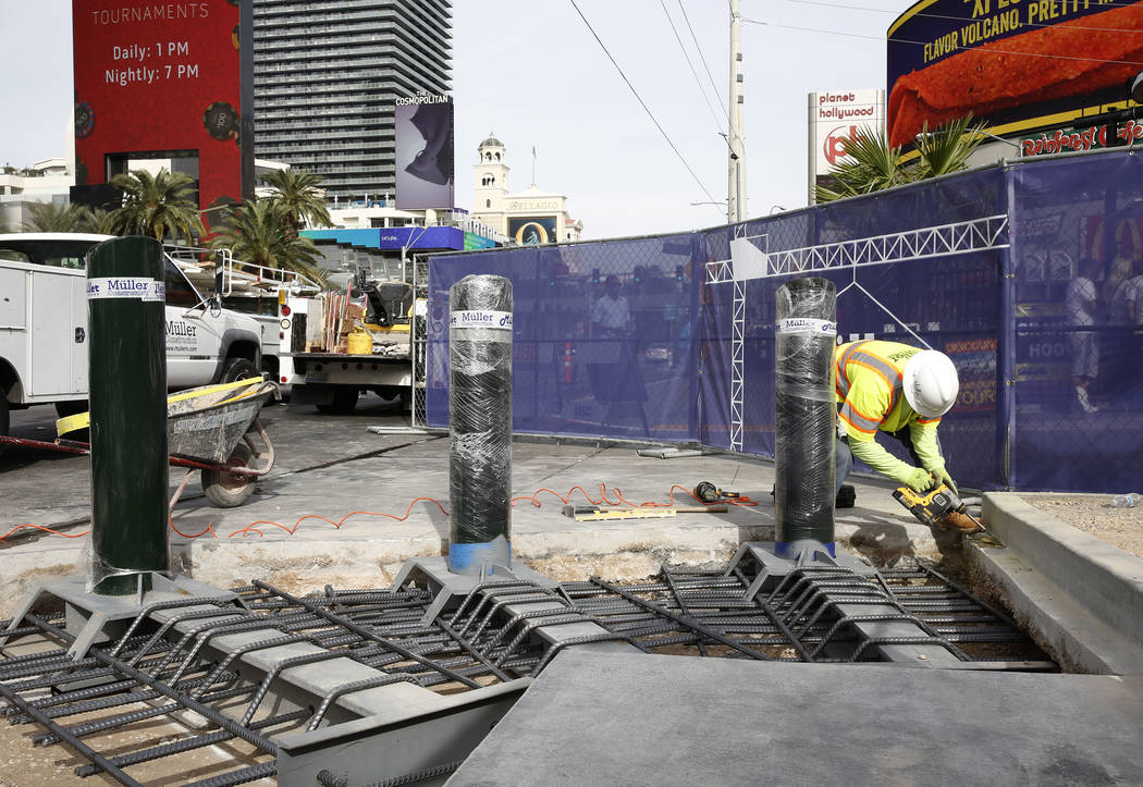 A construction worker installs steel posts on the Strip near Aria hotel-casino Monday, Nov. 13, 2017 to protect pedestrians, locals and tourists walking along Las Vegas Boulevard. Bizuayehu Tesfay ...