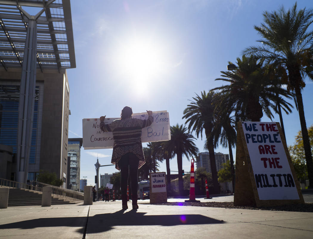 Julie Setzer holds signs in support of the Bundy family and others outside the in Lloyd George U.S. Courthouse in downtown Las Vegas on Tuesday, Nov. 14, 2017. Opening statements were delivered in ...