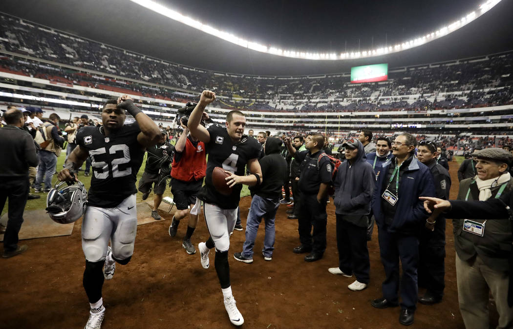 Oakland Raiders quarterback Derek Carr, center, and defensive end Khalil Mack (52) celebrate after their NFL football game against the Houston Texans Monday, Nov. 21, 2016, in Mexico City. The Rai ...