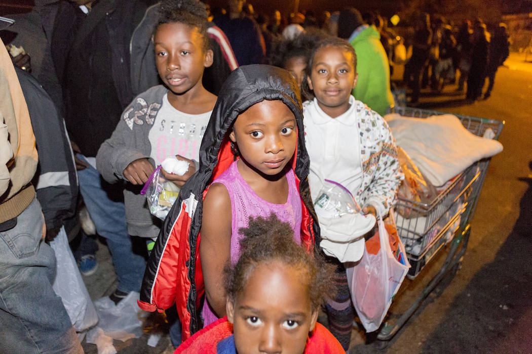 Siblings and cousins amongst other individuals wait in line to get winter coats and food with her siblings and cousins off of H Street and Bonanza Road in Las Vegas, Monday, Nov. 20, 2017.  Elizab ...