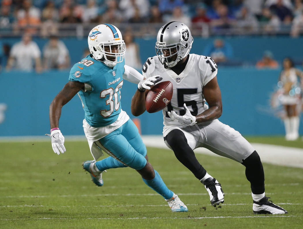 Oakland Raiders wide receiver Michael Crabtree (15) catches the ball ahead of Miami Dolphins cornerback Cordrea Tankersley (30), during the first half of an NFL football game, Sunday, Nov. 5, 2017 ...