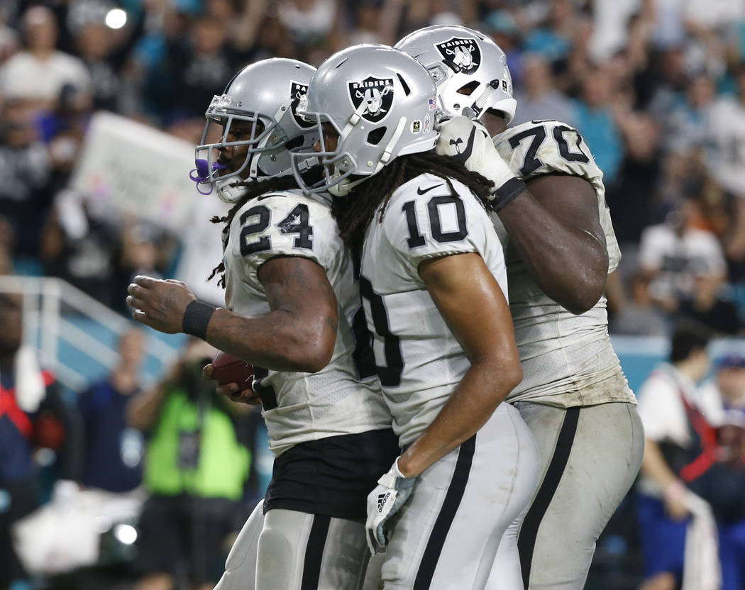 Oakland Raiders wide receiver Seth Roberts (10) and offensive guard Kelechi Osemele (70), congratulate running back Marshawn Lynch (24) after Lynch scored a touchdown, during the second half of an ...