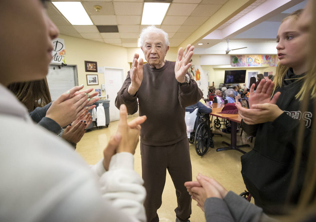 Ninety-year-old Leon Goldstein claps his hands during a dance with a group of Faith Lutheran sixth graders volunteering at the Nevada Senior Services Adult Day Care Of Las Vegas on Friday, Nov. 17 ...